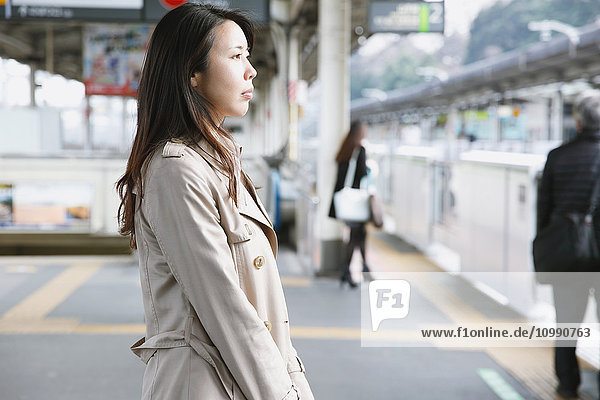 Young attractive Japanese woman waiting for the train