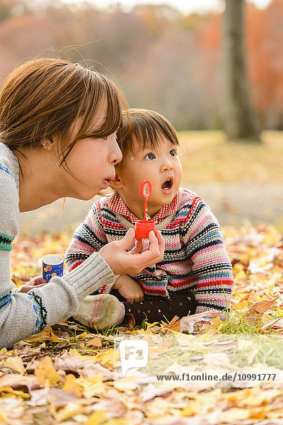Kind spielt mit seiner Mutter im Park