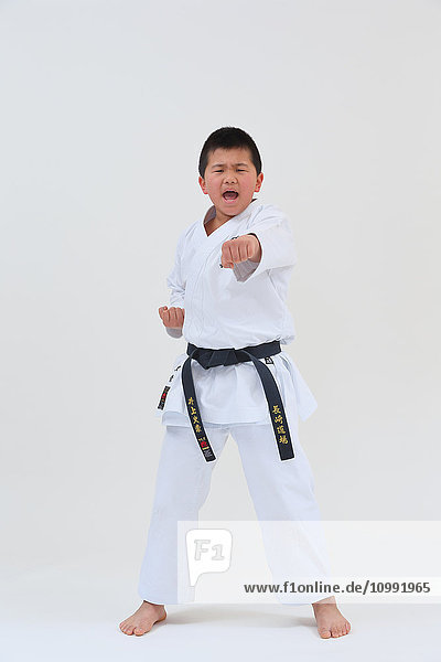 Japanischer Junge in Karate-Uniform auf weißem Hintergrund