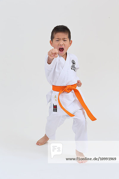 Japanischer Junge in Karate-Uniform auf weißem Hintergrund