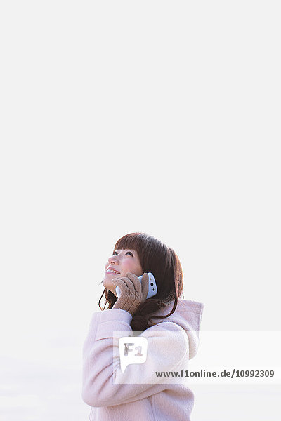 Attractive Japanese woman on the phone on a Winter day