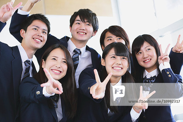 Japanische Schülerin macht Gruppenfoto im Klassenzimmer