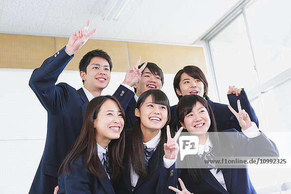 Japanese high-school student taking group shot in classroom