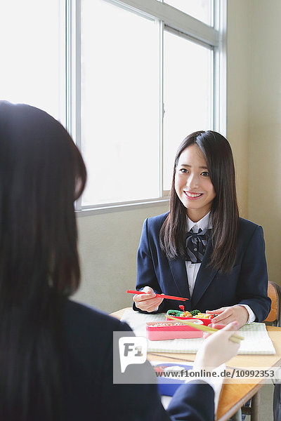 Japanische Oberschüler essen Bento im Klassenzimmer