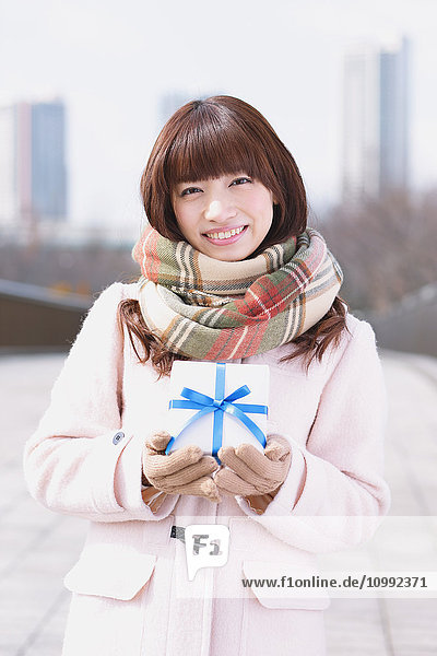Attraktive japanische Frau mit Geschenk an einem Wintertag