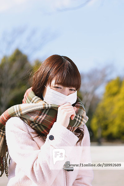 Attractive Japanese woman feeling sick on a Winter day