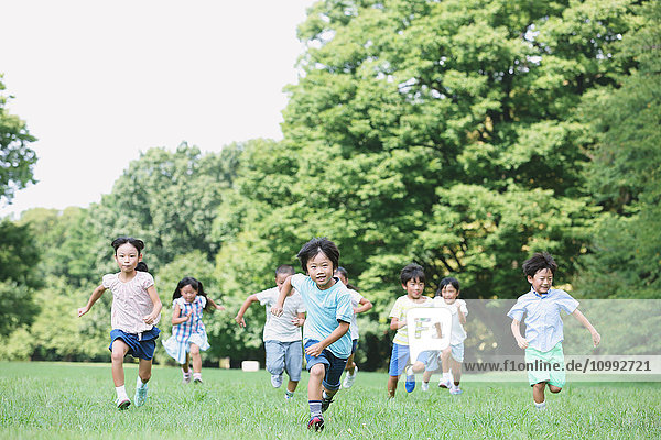 Japanese kids running in a city park