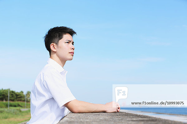 Portrait of young Japanese man by the sea