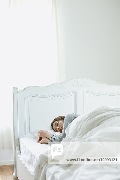 Junge attraktive japanische Frau schläft im Bett