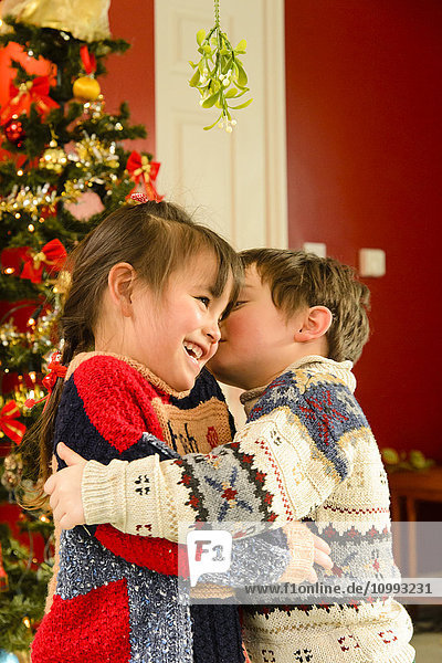 Küssende Kinder im Haus zu Weihnachten