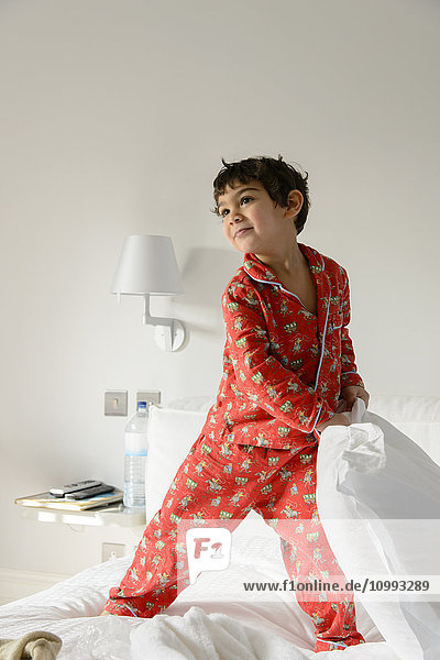 Kid playing on bed in a pijama
