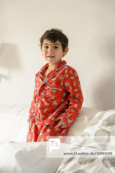 Kind spielt auf dem Bett im Pijama
