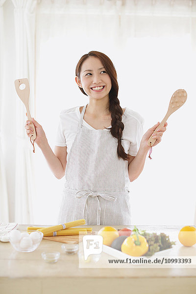 Young attractive Japanese woman cooking at home