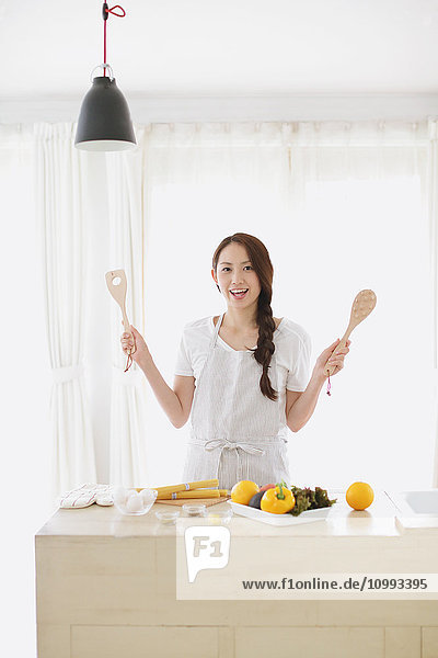 Young attractive Japanese woman cooking at home