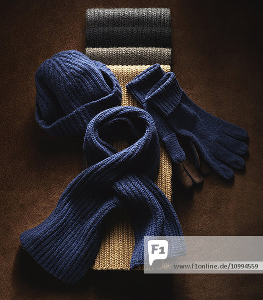 Wollmütze  Schals und Handschuhe  Studioaufnahme auf braunem Hintergrund