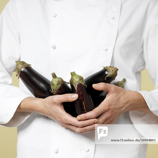 Close-up of Woman's Hands holding Eggplants