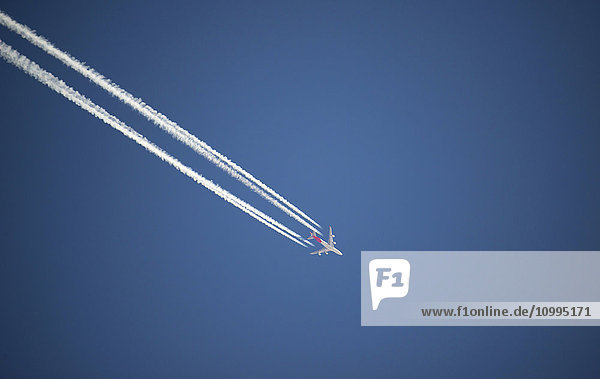 Airplane And Contrails Against Blue Sky Canada