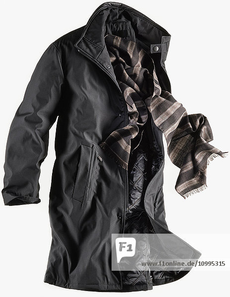 Dunkel gefärbter Mantel mit Schal auf weißem Hintergrund