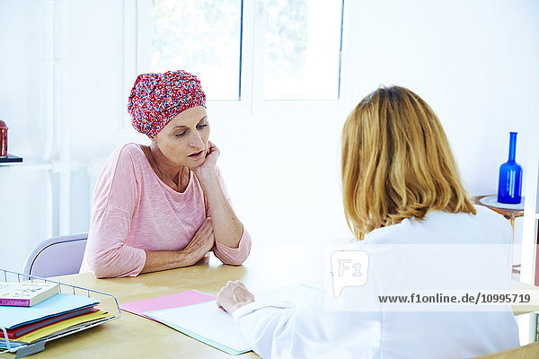 Woman suffering from cancer talking to her doctor.