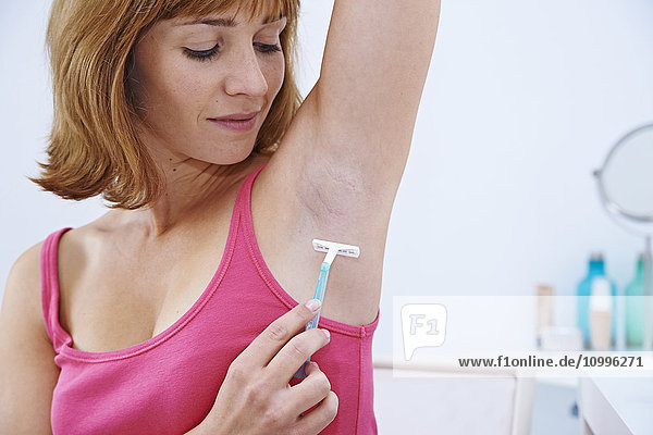 Woman shaving her armpits.