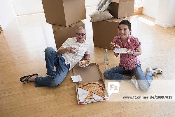 Pärchen isst Pizza in neuer Wohnung