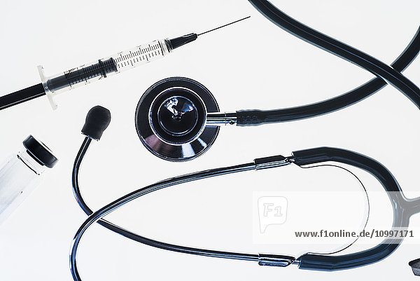 Stethoscope syringe and test tube on white background