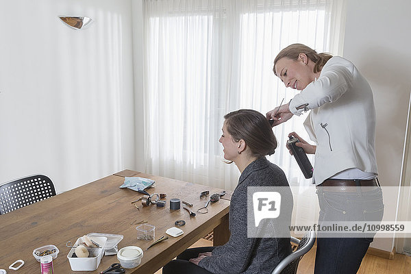 Frau stylt das Haar einer anderen Frau