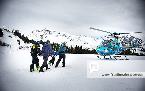 Reportage with a ski patrol team at the Avoriaz ski resort in Haute Savoie  France. The team are responsible for marking out the ski slopes  providing first aid to skiers  evacuations on the slopes as well as off piste and controlled avalanches. The patrol team evacuate a woman by helicopter who is injured.