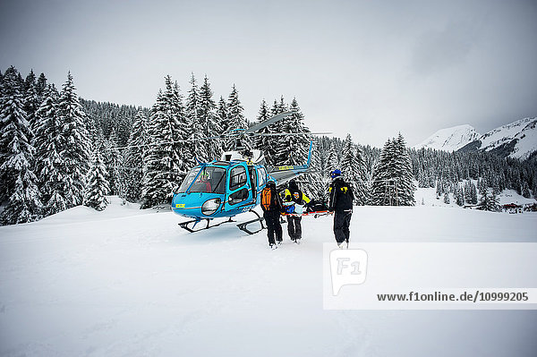 Reportage with a ski patrol team at the Avoriaz ski resort in Haute Savoie  France. The team are responsible for marking out the ski slopes  providing first aid to skiers  evacuations on the slopes as well as off piste and controlled avalanches. The patrol team evacuate a woman by helicopter who has a shoulder injury.