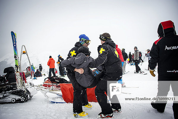Reportage with a ski patrol team at the Avoriaz ski resort in Haute Savoie  France. The team are responsible for marking out the ski slopes  providing first aid to skiers  evacuations on the slopes as well as off piste and controlled avalanches. The patrol team evacuate a skier who has a knee injury.
