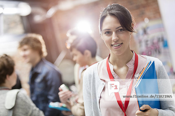 Portrait smiling woman holding folder at technology conference