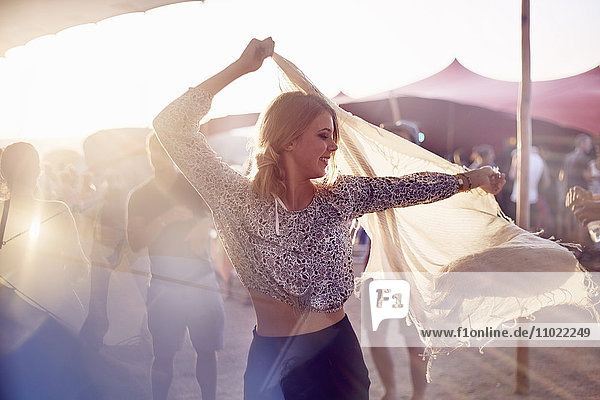 Junge Frau tanzt mit Schal beim Musikfestival