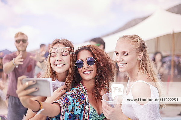 Junge Frauen posieren für Selfie beim Musikfestival