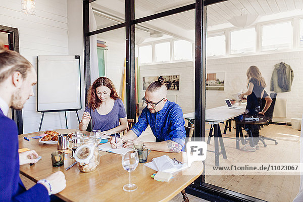 Creative business people working at table in board room