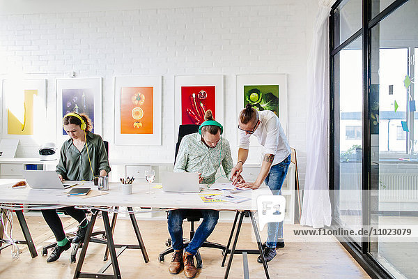 Team of creative business people working at table in office