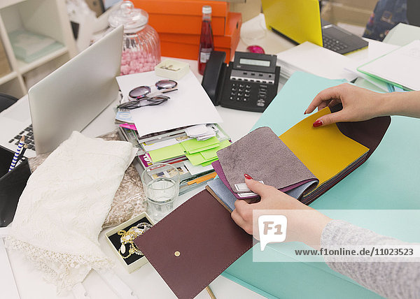 Fashion buyer browsing fabric swatches at desk