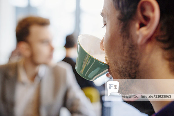 Cropped image of young man drinking tea at restaurant