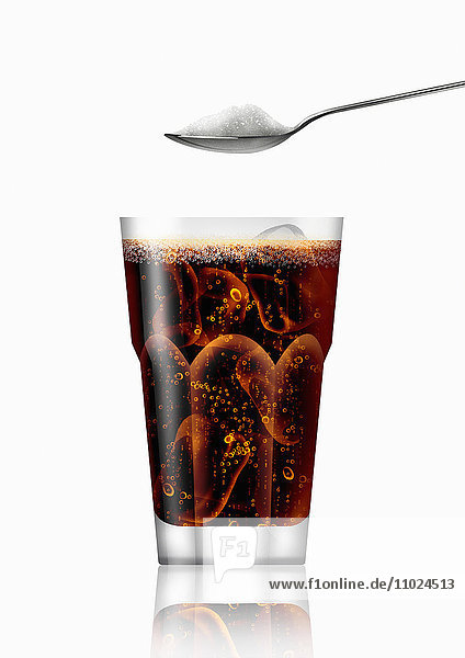 Teelöffel mit Zucker über einem Glas Cola