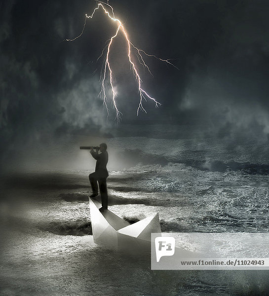 Geschäftsmann in sinkendem Papierboot auf dem Meer im Sturm schaut durch ein Fernrohr