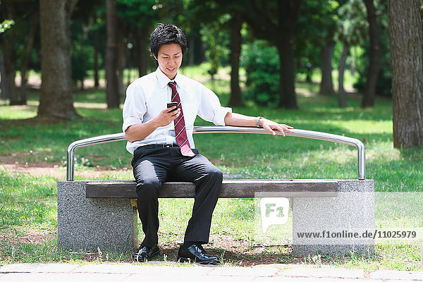 Young Japanese businessman with smartphone