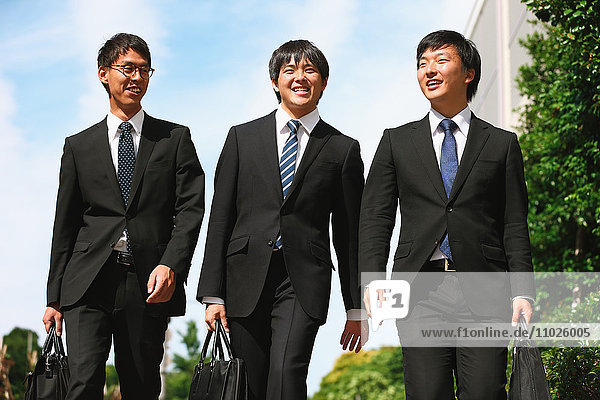 Junge japanische Geschäftsleute beim Spaziergang