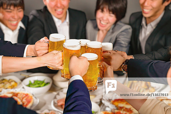 Gruppe junger japanischer Freunde  die mit Bier anstoßen