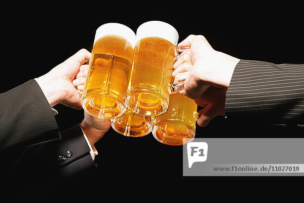 Gruppe junger japanischer Freunde  die mit Bier anstoßen