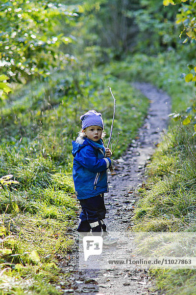 Junge im Wald schaut in die Kamera