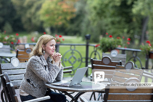 Mature woman using laptop in bar