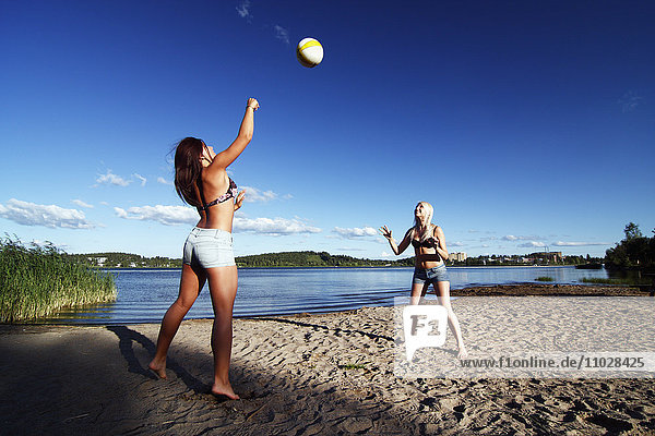 Frauen spielen Volleyball am Strand