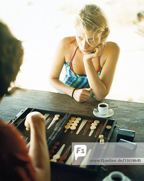 Eine junge Frau spielt Backgammon.