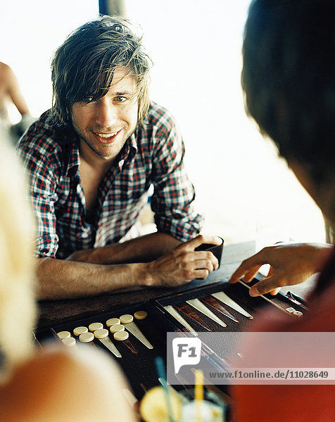 Ein Mann spielt Backgammon.