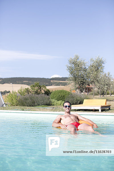 Mid adult man relaxing in swimming pool