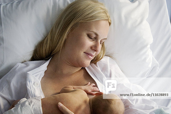 A mother breast feeding a baby.